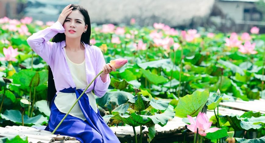 Femme cueillant une fleur lotus